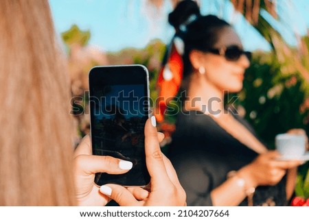 Happy girlfriends taking photo on vacation Concept of friendship and fun in the summer Best friends enjoying moments with modern smartphone. Traveling bloggers. Social media