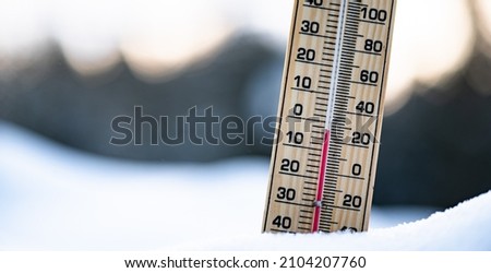 Winter time. thermometer on snow shows low temperatures.