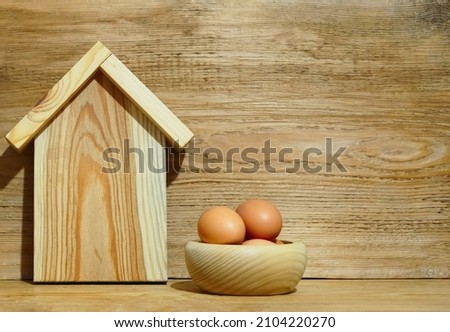rustic composition on the kitchen interior with sign of wooden house,  easter eggs on wood board background. 