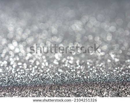 silver Sparkling Lights Festive background with texture. Abstract Christmas twinkled bright bokeh defocused and Falling stars. Winter Card or invitation
