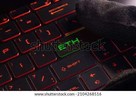 Close-up laptop keyboard with Red and green light button Hack. Finger in glove