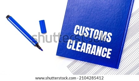 On a white background reports, a blue pen and a blue notebook with the text CUSTOMS CLEARANCE. Business concept. Banner