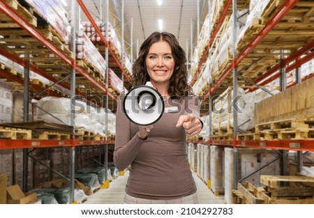 sale, shopping and business concept - happy female worker or storekeeper with megaphone and name tag over warehouse background Royalty-Free Stock Photo #2104292783