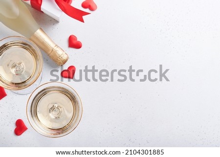 Valentines day background with champagne glasses and gift box with red ribbon. 8 March, Womens Mothers Valentines Day, Birthday. Flat lay, top view, copy space.