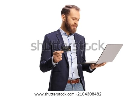 Young man using a credit card and a laptop computer isolated on white background