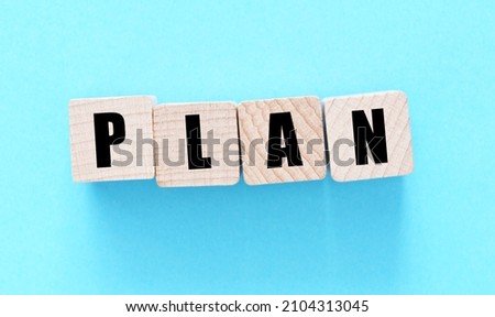 PLAN word on wooden blocks and a blue background.