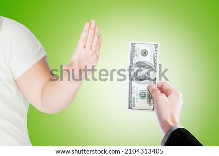 Close up of young man hand refusing bribe money from a businessman while standing in the studio with green screen background