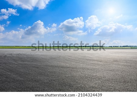 Asphalt road and green fields nature landscape in spring season Royalty-Free Stock Photo #2104324439