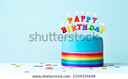 Colorful rainbow birthday cake with rainbow ribbon and rainbow birthday candles
