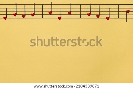 The musical melody is written in the form of hearts. Melody of love on yellow background