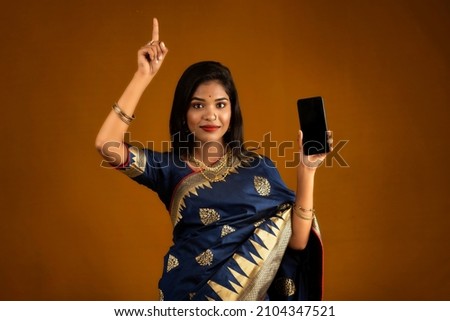 Young beautiful girl showing a blank screen of smartphone or mobile or tablet phone
