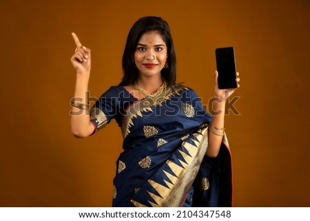 Young beautiful girl showing a blank screen of smartphone or mobile or tablet phone
