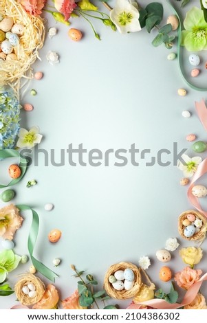 Happy Easter concept with easter eggs in nest and spring flowers. Easter background with copy space. Flat lay. Royalty-Free Stock Photo #2104386302