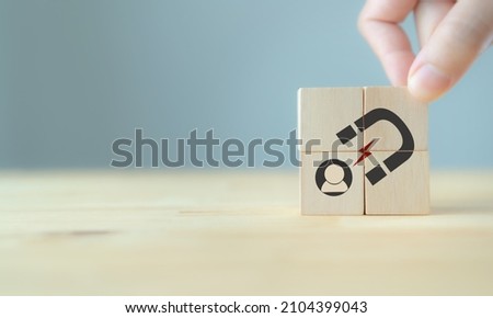 Lead generation, customer retention concept. Inbound marketing strategy. Hand puts wooden cubes with magnet attracts customer icons on beautiful grey background and copy space. Brand loyalty banner. Royalty-Free Stock Photo #2104399043