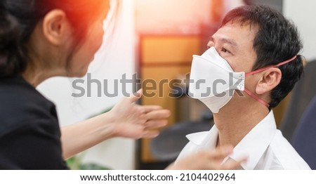 Respirator fit test prepared for COVID-19. Asia man testing repiratory system with N-95 surgical mask to checks properly fits face to wears. Royalty-Free Stock Photo #2104402964