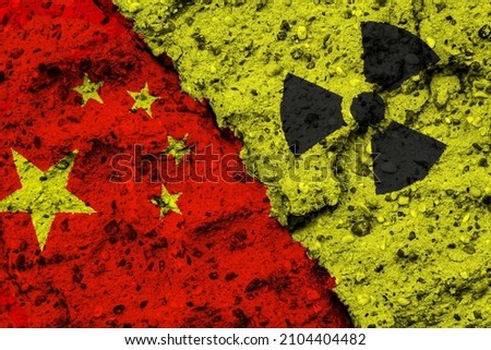 Concept of the Nuclear Energy Policy of the Peoples Republic of China with a flag and a radiation hazard sign painted on a rough wall
