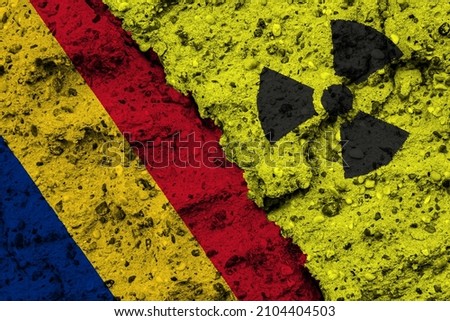 Concept of the Nuclear Energy Policy of Roumania with a flag and a radiation hazard sign painted on a rough wall
