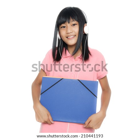 Teenage girl holding a book listening music on white background 