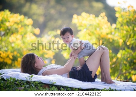 Young mother carried little daughter in the park. Sweet mother with baby. Takecare and family lifestyle. 