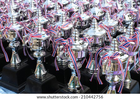 Many shiny silver trophies in a rows