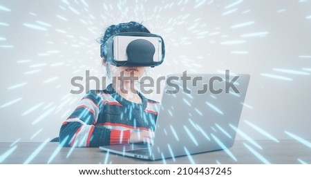 The little girl wearing VR sitting at desk in the home glasses virtual Global Internet connection metaverse. Future kids in white clothing wearing VR headsets for a game. concept advanced technology.