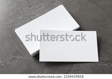 Blank business cards on grey table, above view. Mockup for design