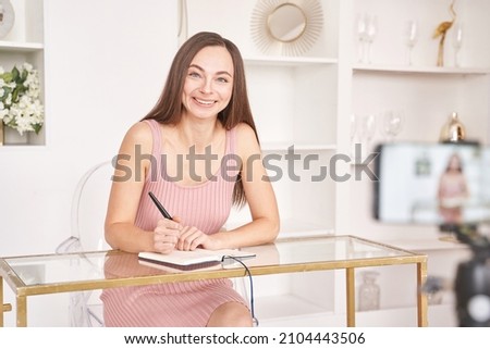 Young woman doing self portrait indoors. Home vacation portrait. Blogger selfie. Alone in interior. Happy emotion. Smiling female person. Lifestyle action. Posing