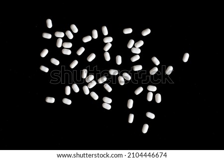 large group of white candies on black background