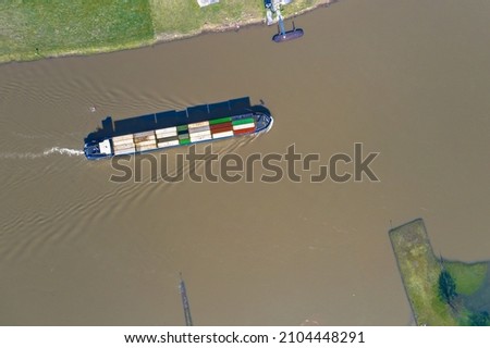 Inland container vessel on River Lek aerial view near the village of Ravenswaaij, Gelderland, Netherlands Royalty-Free Stock Photo #2104448291