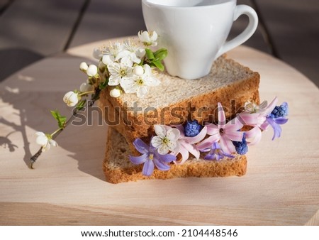 Sandwich toast bread with spring flowers and a cup of coffee - a beautiful healthy breakfast. good morning, flower fantasies, positive atmosphere, flora inspiration. Hello Spring