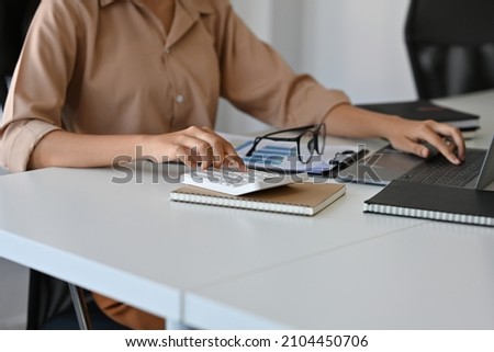 Close up with Accountant working with laptop and calculator for analyze business data, accountancy document. 