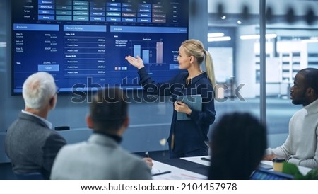 Diverse Modern Office: Successful Businesswoman Uses TV Screen with Big Data, Statistics, Talks about Company Growth, Discusses Strategy with Investors. Information Technology Expert Talks