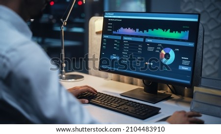 Close Up of a Businessman Working on Desktop Computer with Company's Growth, Statistics, Graphs and Pie Charts. Male Executive Director Managing Digital Projects, Typing Data, Using Keyboard and Mouse Royalty-Free Stock Photo #2104483910