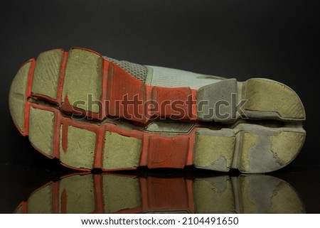 Old and Worn Out Rubber Shoe Soles. It Strange with Orange and grey color. Royalty-Free Stock Photo #2104491650