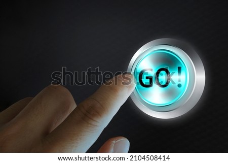 Man finger about to press an action button with the text go, black background and blue light. Composite between a photography and a 3D background. Entrepreneurship concept.
