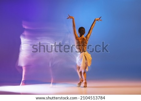 Solo. Portrait of young graceful flexible woman dancing ballroom dance without partner isolated on gradient blue purple background in neon mixed light. Concept of art, timeless, beauty, music, style