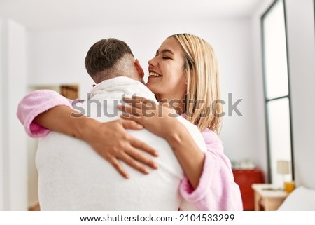 Young caucasian couple smiling happy and hugging standing at bedroom.
