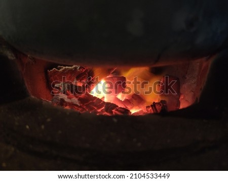 Picture of coals burning under the pot.