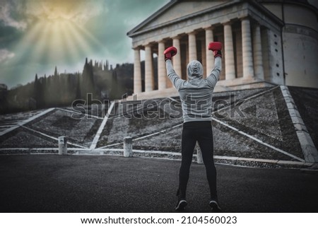 Winning boxer raises his hands high. Victory at the Rocky Balboa. Royalty-Free Stock Photo #2104560023