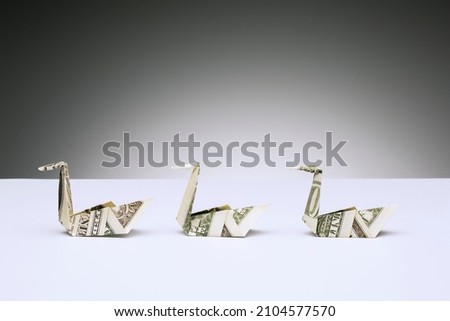 Origami swans made of dollar bills on counter