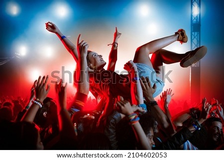 Man crowd surfing at music festival Royalty-Free Stock Photo #2104602053