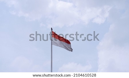 Indonesian Flag, Red and White, with cloudy sky background