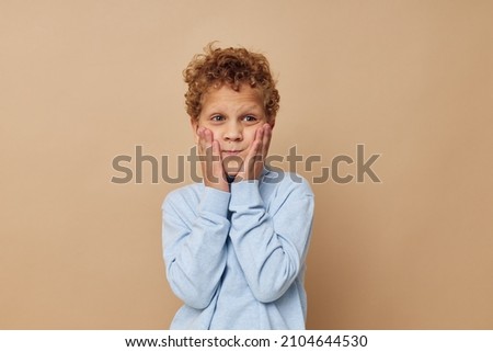 Photo of young boy in a blue sweater posing fun isolated background