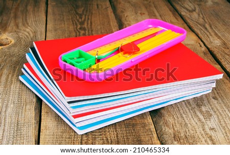 School tools and writing-books. On a wooden background.