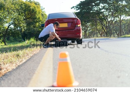 Emergency stop sign and man with broken down car on the highway
