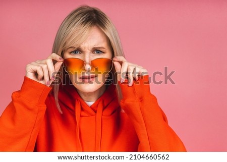 Amazed shocked surprised young blonde woman looking at camera isolated on pink background.