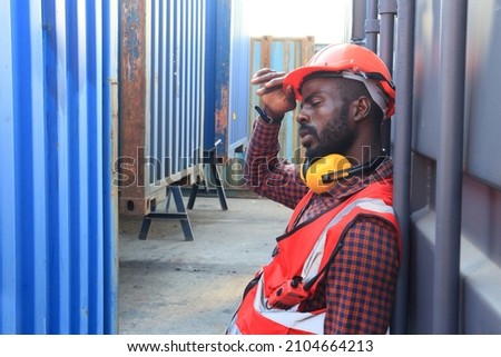 Close up of An African American handsome black engineer he is working in container box yard area of  logistics transportation import export or shipping industry 