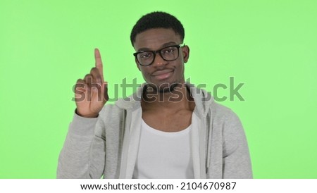 Disliking African Man showing No Sign by Finger on Green Background