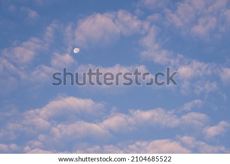 The moon in the blue sky among the clouds is like a background