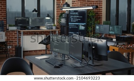 Computer screens running programming code in empty software it agency office and computers parsing data algorithms in background. Neural network servers cloud computing in data room. Royalty-Free Stock Photo #2104693223